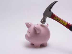 piggy bank about to be broken open by a hammer
