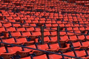 empty sports arena with rows of red stadium chairs