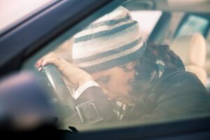 driver sleeping with head rested on steering wheel