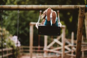 child playing on a swing at a playground