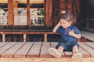 toddler sitting on a wooden porch