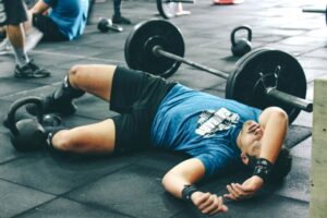 injured weightlifter lying on the floor of gym