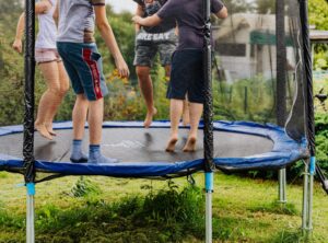 children jumping on an outdoor trampoline