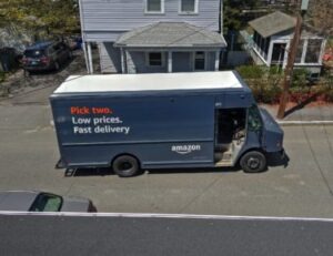 blue delivery truck parked in front of house