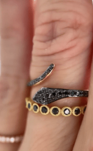 A woman pairs a custom black diamond eternity band with different rings.