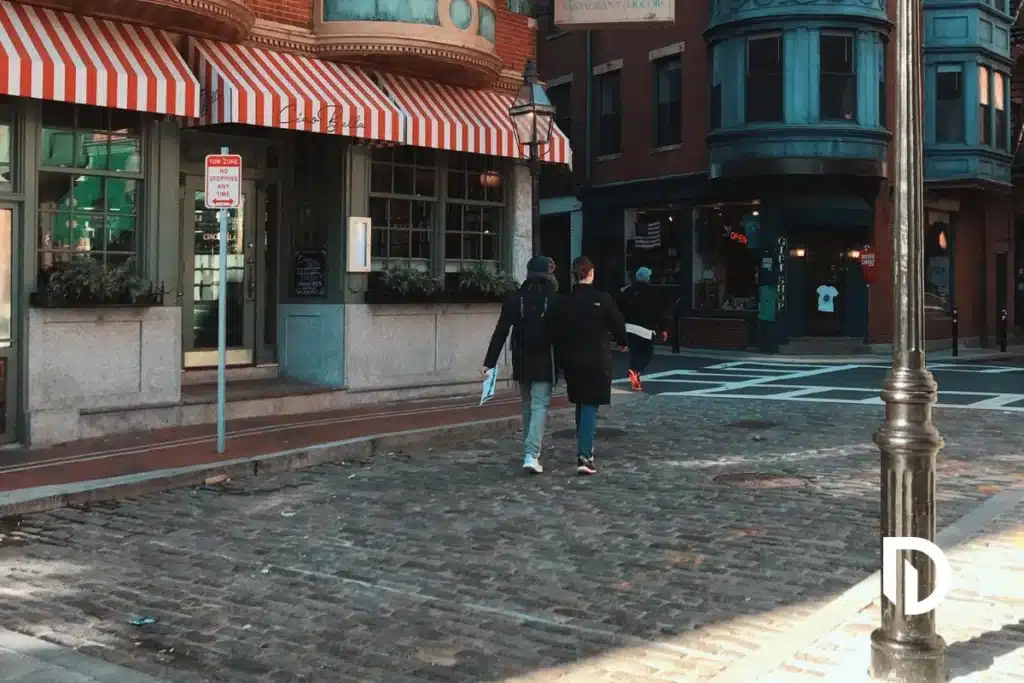 Two women jaywalking on a Boston street