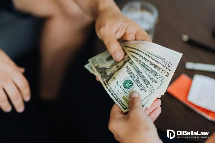 Male hand handing money to another hand paying out of pocket