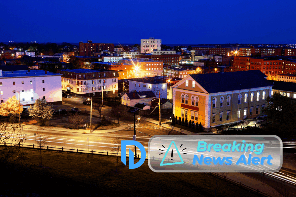 night time aerial view of Lynn, MA with "Breaking News" and the DiBella logo overlay in the corner