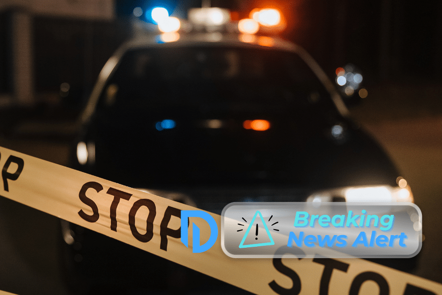 "stop" caution tape in front of a police car with it's lights on