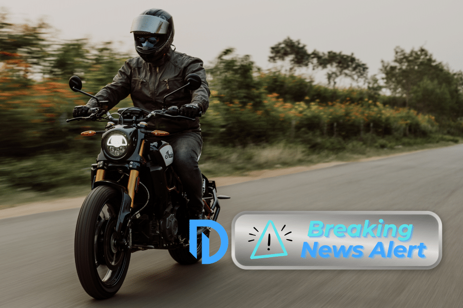man riding a motorcycle and a "breaking news" logo overlay in the bottom right hand corner