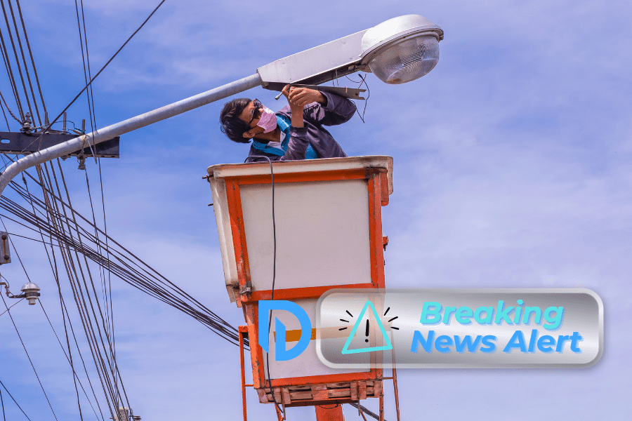 Massachusetts utility worker in a bucket tending to electrical work on a lamp post