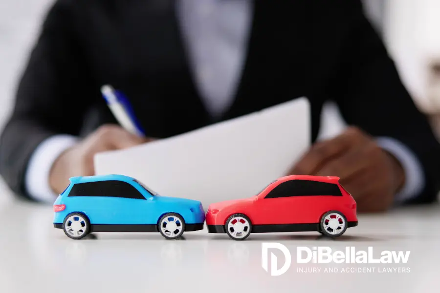 two toy cars depicting a crash on table in front of a lawyer