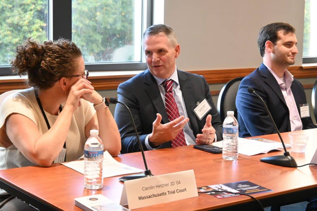 Chris DiBella talking with other panelists at the Suffolk Law school