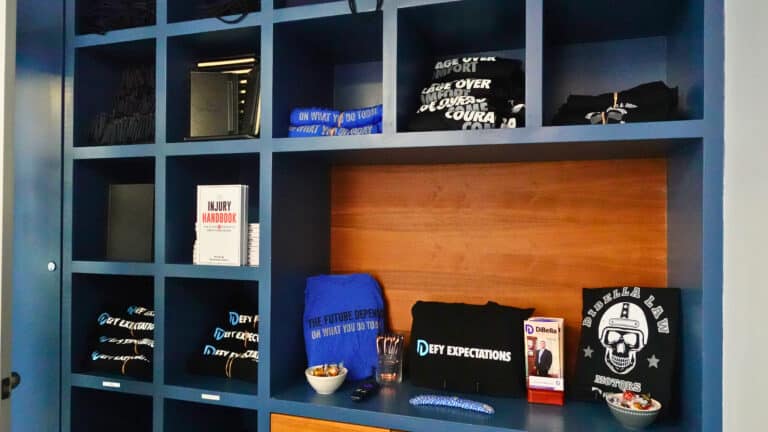 Shelves at DiBella Law's Boston personal injury office filled with swag and merchandise