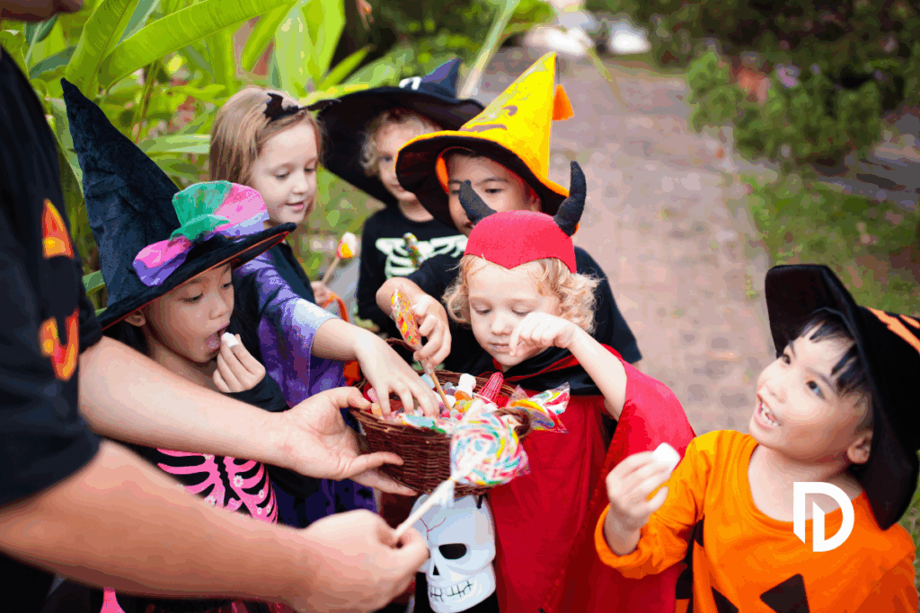 Group of kids on beggars night getting candy from someone handing it out from their home in MA