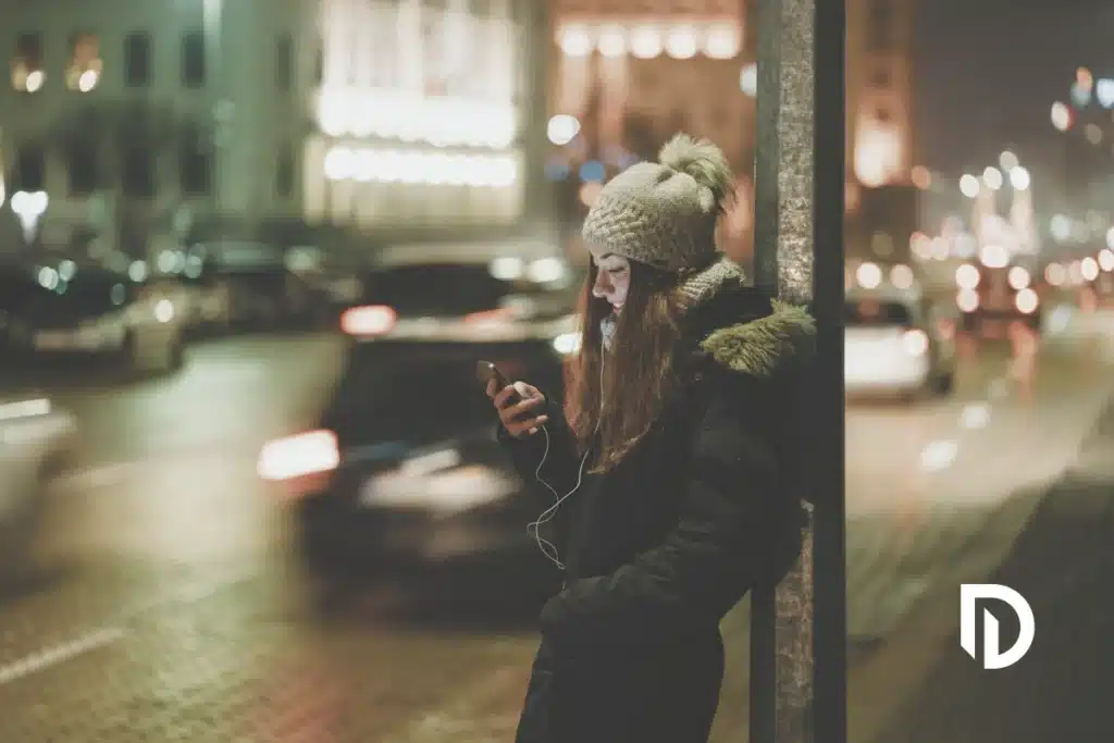 young woman using her phone to order an Uber for pick up in Massachusetts