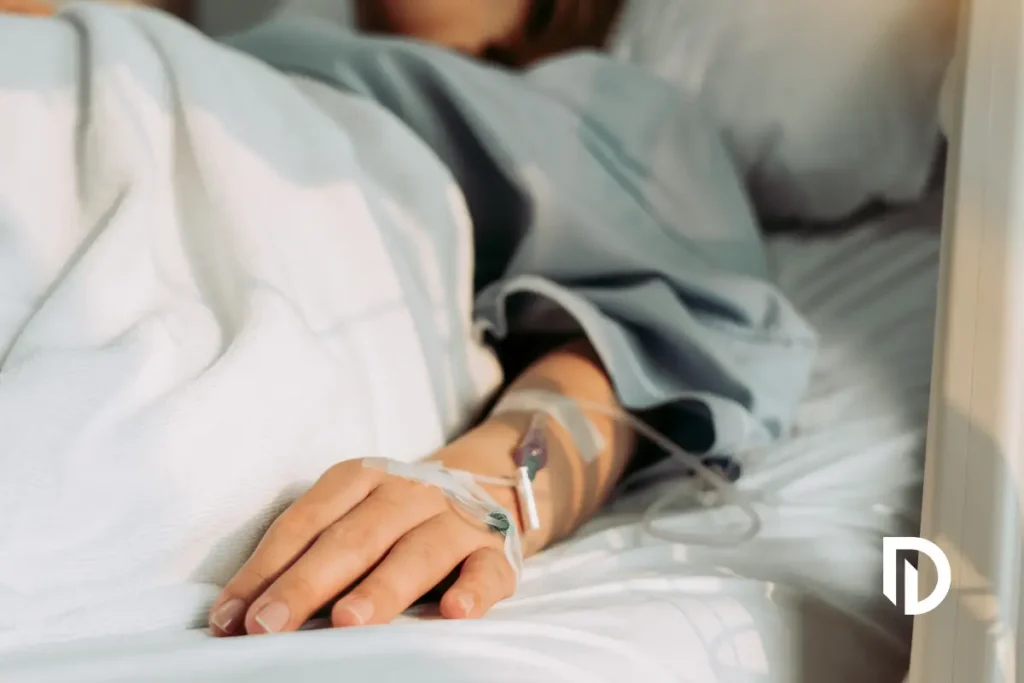 a medical IV line inserted into the back of the hand of a person's hand