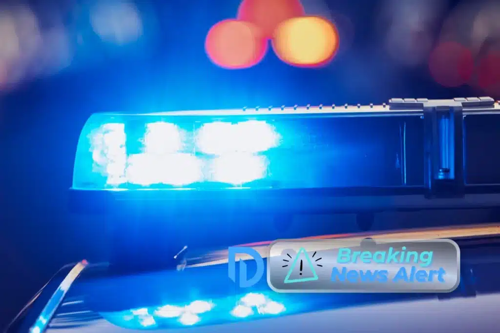 Close up image of a police siren at night, lit up blue.