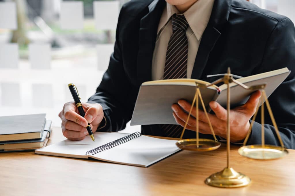 lawyer-writing-in-office-with-scales-of-justice