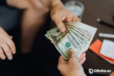 Male hand handing money to another hand paying out of pocket